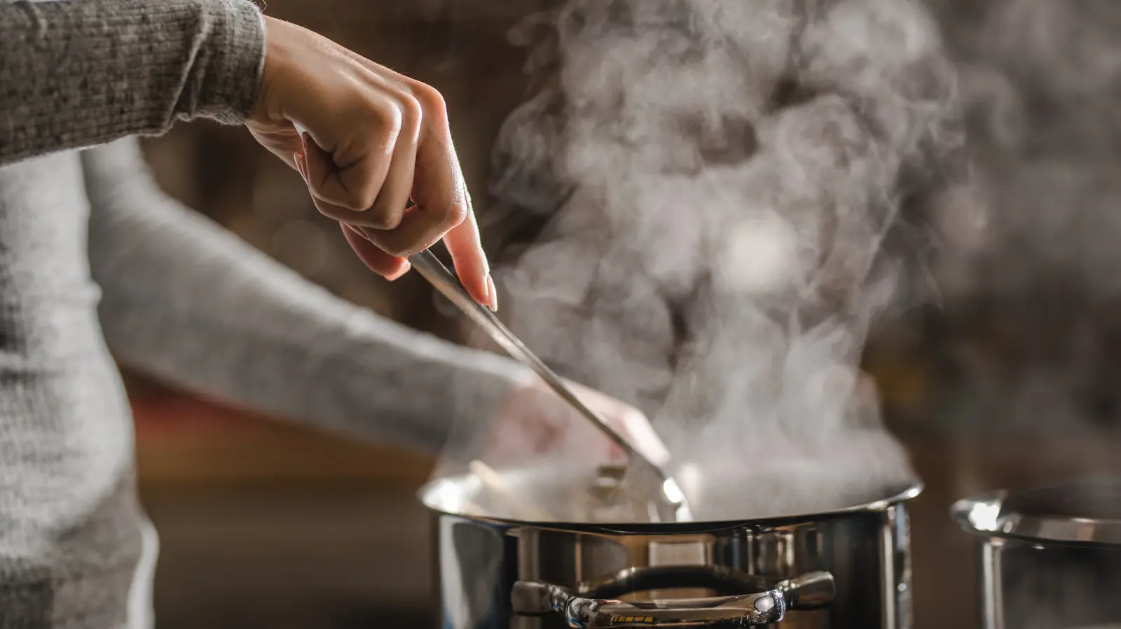 Home Cook Reheats Leftover Food With The Help Of Boiling Water On The Stove