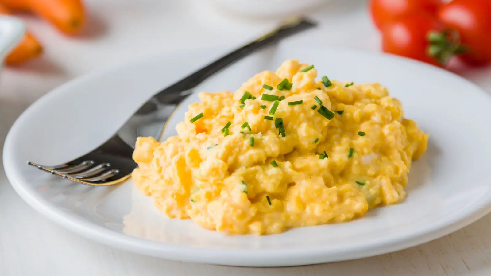 A single splash of high-fat cream transforms ordinary scrambled eggs into a luxurious dish
